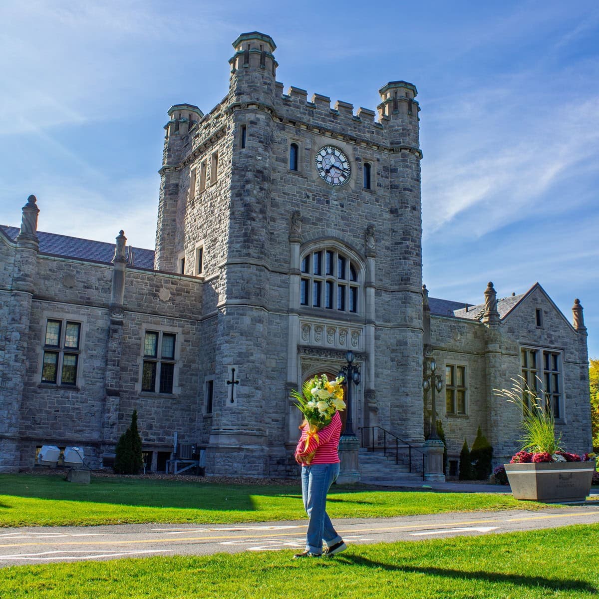 Person holding a yellow and white bouquet in front of Westmount City Hall