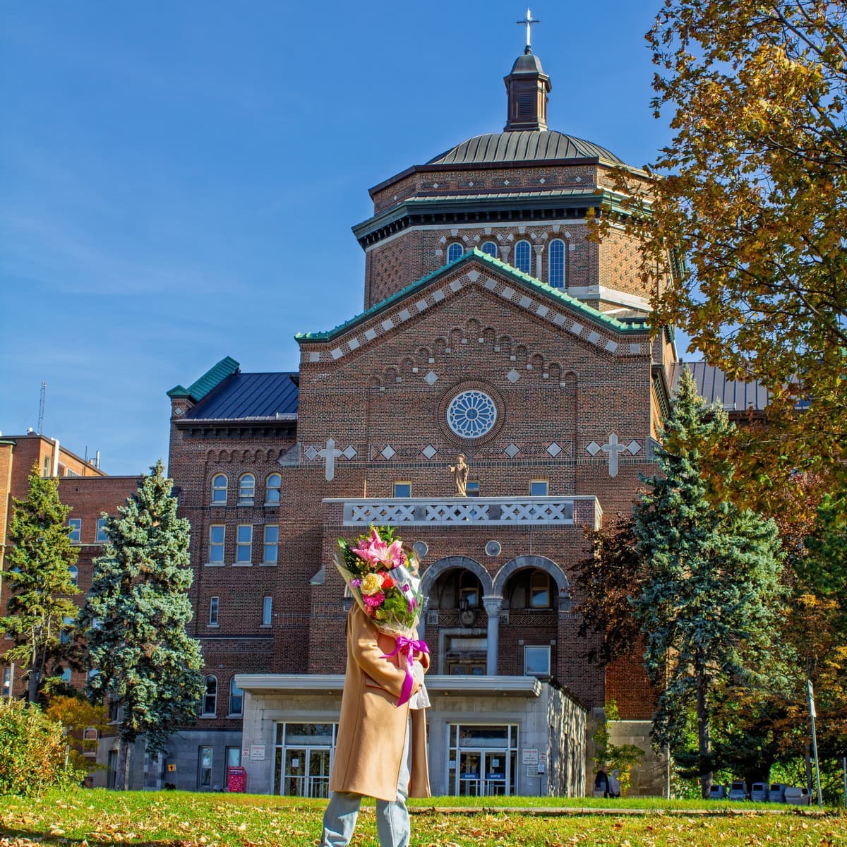 Person holding a colourful bouquet in front of Hôpital du Sacré-Cœur de Montréal in Ahuntsic-Cartierville