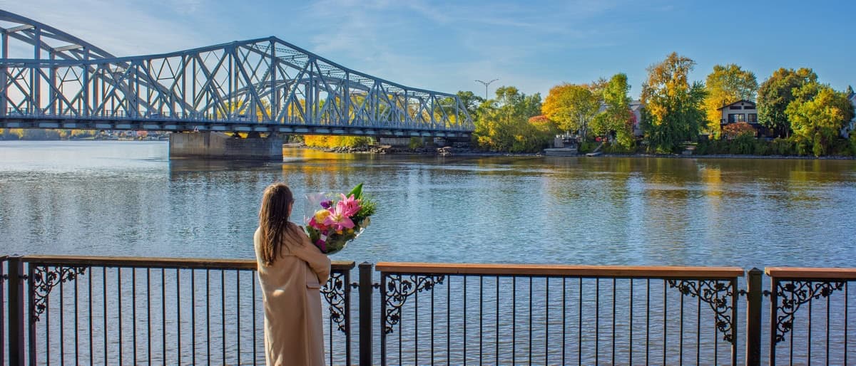 Person holding a colourful bouquet by the waterfront at Parc Belmont in Ahuntsic-Cartierville, Montreal